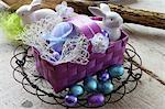 A basket of Easter eggs, porcelain rabbits and chocolate eggs