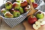 A basket of organic apples and sliced apples on a board