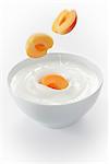 Aprikosen fallen in eine Schüssel mit Joghurt