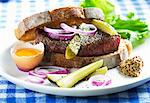 A beef sandwich with gherkins, egg, onion and mustard
