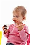 A small child eating a chocolate marshmallow