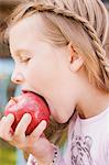 Une jeune fille de mordre dans une pomme