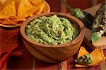 Guacamole in a Wooden Bowl; Tortilla Chips; Charred Jalapeno Peppers