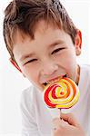 A little boy biting into a lolly