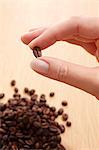 Fingers holding a coffee bean