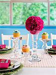 A festively laid table with flower balls and cupcakes