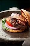 Grilled Hamburger with Bacon, Tomato, Onion and Lettuce on a Toasted Bun