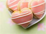 A bowl of pink heart biscuits filled with jam