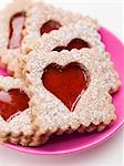 Jam biscuits with icing sugar on a plate