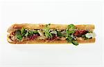 A chicken and dried tomato sandwich on a baguette