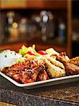 A chicken platter with dips and vegetables