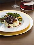 Braised beef ribs on mashed potatoes with chard and red wine