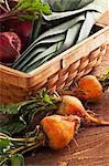 Organiques betteraves dorées à côté d'un panier rempli de poireaux et betteraves rouges