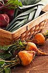 Organic Golden Beets Next to a Basket Filled with Red Beets and Leeks