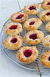 Coconut macaroons with raspberry jam on a wire rack