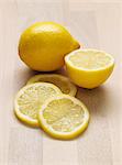 Citron entier, un demi-citron et tranches de citron