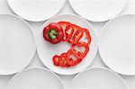 Tomato Slices In Plate Surrounded By Other Empty Plates