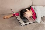 Woman sleeping on laptop on couch