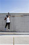 Man scaling wall on city street