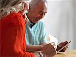 Older couple reading mail in kitchen