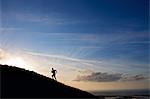 Silhouette du randonneur à flanc de colline en courant