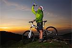 Mountain biker drinking water on hilltop