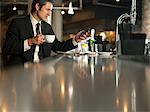 Homme d'affaires à l'aide de téléphone portable dans le cafe