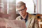 Man reading a newspaper in a restaurant