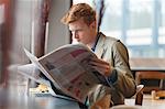 Man sitting in a restaurant and reading a newspaper