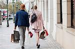 Rear view of a couple carrying shopping bags