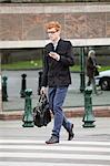 Man crossing the road while using a mobile phone