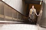 Businesswoman standing on escalator