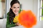 Happy woman holding a feather duster