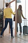 Woman welcoming her friend at doorway