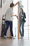 Woman arriving at her friends home with a wine bottle