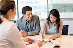 Couple signing documents with real estate agent