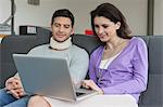 Femme utilisant un ordinateur portable avec son mari à côté d'elle