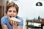 Woman eating toast with cream spread on it