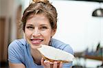 Portrait of a woman eating toast with cream spread on it