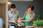 Femme aide son fils pour cuire les aliments