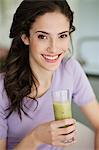 Woman holding a glass of cold soup and smiling