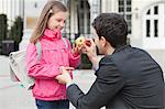 Man giving an apple to his daughter