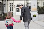 Girl walking towards school with her father