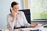 Businesswoman talking on a landline phone in an office