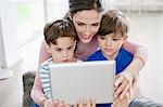 Woman showing a digital tablet to their children