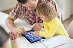 Man teaching digital tablet to his daughter