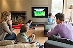 Family using electronic gadgets in a living room