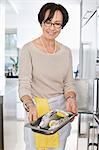 Elderly woman showing a tray of seafood in front of an oven