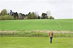 Mann mit einem Mobiltelefon in einem Feld