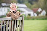 Homme assis sur un banc et penser dans un parc